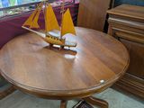 une petite table sur laquelle se trouve un voilier, dans une pièce