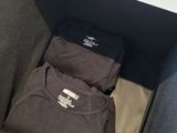 two t - shirts sitting in a box on a table