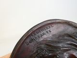 a statue of a man with a beard on a wooden stand