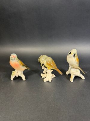 three small figurines of birds sitting on top of each other