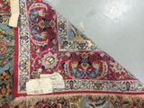 a red and blue rug with a white tag on it