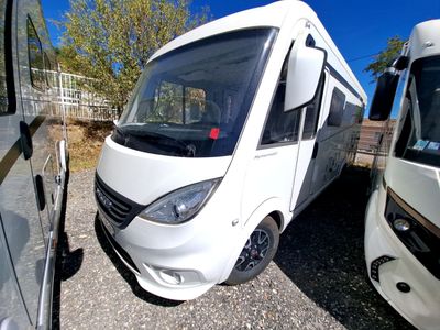un camping-car blanc garé à côté d'un bus blanc