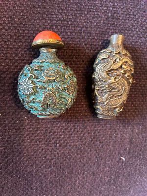 deux flacons à tabac chinois anciens posés sur une surface marron