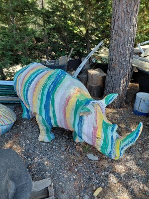 une statue de rhinocéros faite de laine, posée par terre