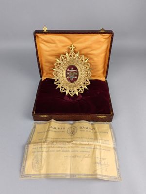 une image représentant une médaille d'or dans un coffret en bois recouvert de velours rouge