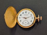 a gold pocket watch sitting on a black surface