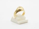 a close up of a gold ring on a white marble block