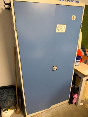 a blue cabinet with a sign on it in the corner of a room
