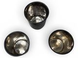 three small metal bowls with lids on a white surface