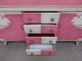 a pink dresser with two drawers and a white top