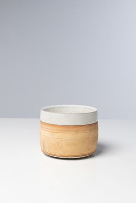 un gros plan d'un bol posé sur une table, sur fond gris