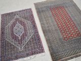 deux tapis orientaux posés côte à côte sur le sol d'une pièce