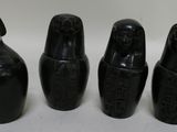 three black vases sitting next to each other on a white surface