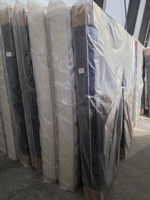many mattresses wrapped up in plastic in a warehouse