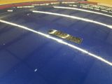 a close up of a shiny blue car with a sticker on it