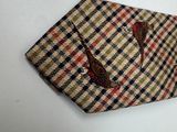 a brown and black checkered tie hanging on a white wall