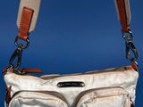 an image of a white purse with a brown strap on a blue background