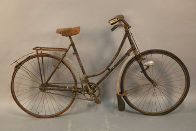 a old bicycle that is leaning up against a wall