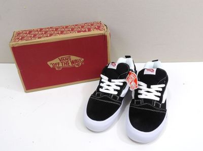 pair of black and white sneakers with a red box in the background