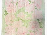 a close up of a pink and green floral scarf on a white background