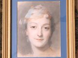 portrait of a woman in a blue dress with a gold frame on a wall