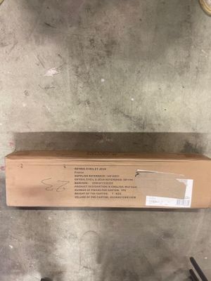 une boîte en carton posée par terre à côté d'une paire de ciseaux