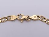 a close up of a gold bracelet on a white surface