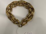 a close up of a gold bracelet with a tag on it
