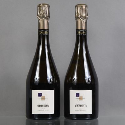 two bottles of wine sitting on top of a table next to each other