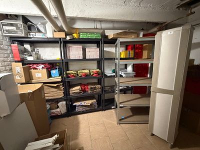 une pièce contenant un réfrigérateur, des étagères, des rayonnages et d'autres objets