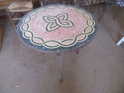 a table with a flower design on it in the middle of a room