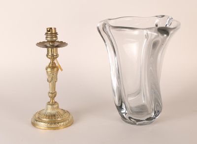 un vase en verre et un bougeoir en laiton posés sur une table