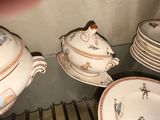 many plates and bowls that are sitting on a glass shelf