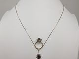 un torse de mannequin blanc orné d'un collier avec un pendentif en forme de fleur