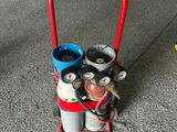 un chariot rouge sur lequel sont empilées plusieurs bouteilles de gaz