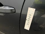 a sticker on the door of a car with a measuring tape attached to it