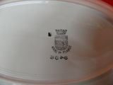 a close up of a white plate with a crest on it