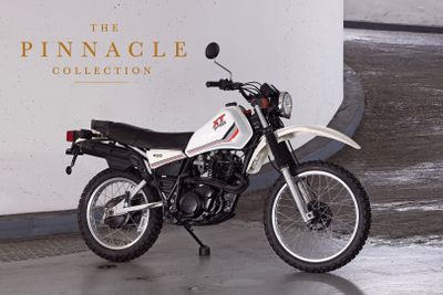 a motorcycle parked in front of the pinnacle collection sign