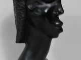 sculpture représentant une tête d'homme coiffée d'une crête iroquoise sur fond blanc
