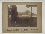 an old photo of a man leaning against a tree in a park