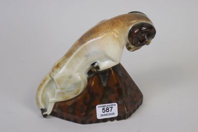 a figurine of a cat sitting on top of a rock