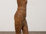 an old wooden statue of a man standing on top of a wooden block