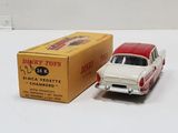a red and white toy car next to a box of cigarettes