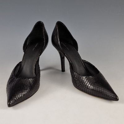 une paire d'escarpins noirs en peau de serpent à bout pointu