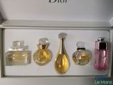 three perfume bottles in a white box on a table