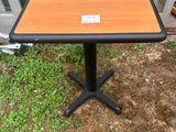 une petite table sur laquelle est posée une étiquette, devant une porte vitrée
