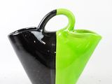 a black and green vase sitting on a white surface