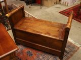 un banc en bois posé sur un tapis dans une pièce