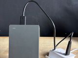 un ordinateur portable et un chargeur posés sur une table en bois