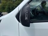 a white van parked in a parking lot with trees in the background